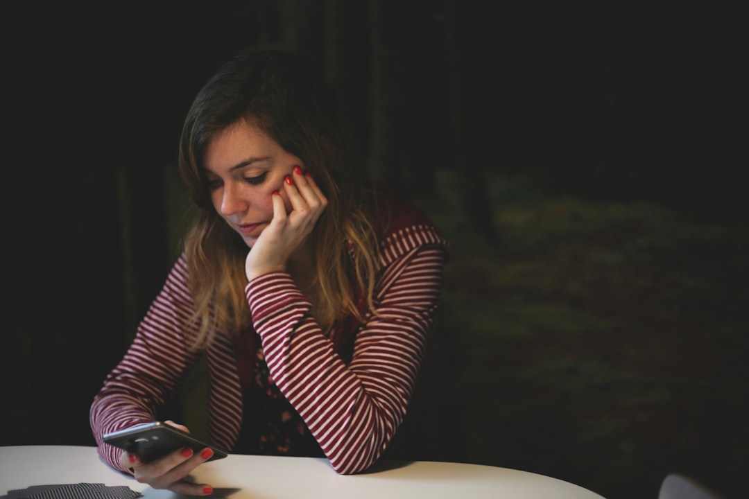 stressed employee looking at phone with worried expression